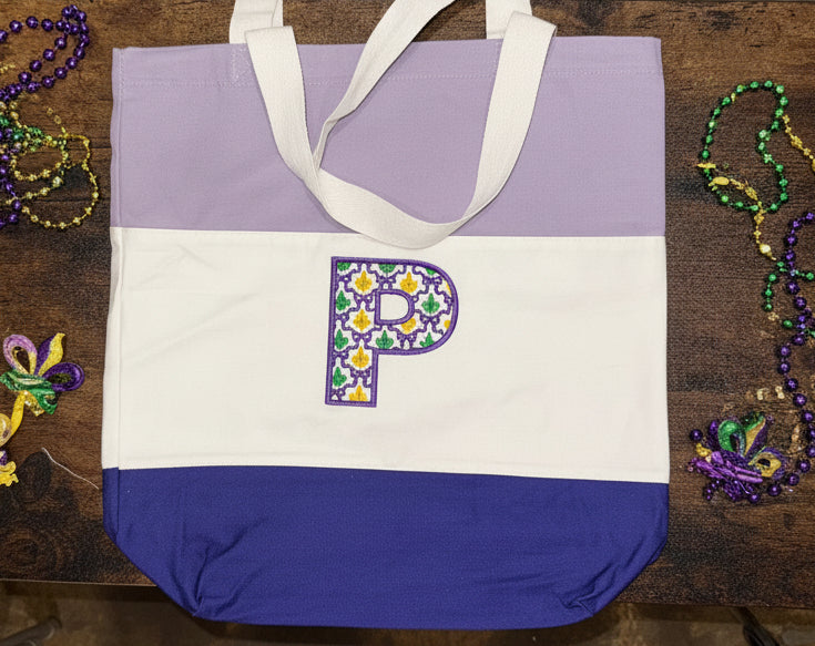 Initial in Mardi Gras Grand Millennial Font (on purple and white bag)